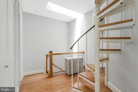a view of staircase with wooden floor and a rug