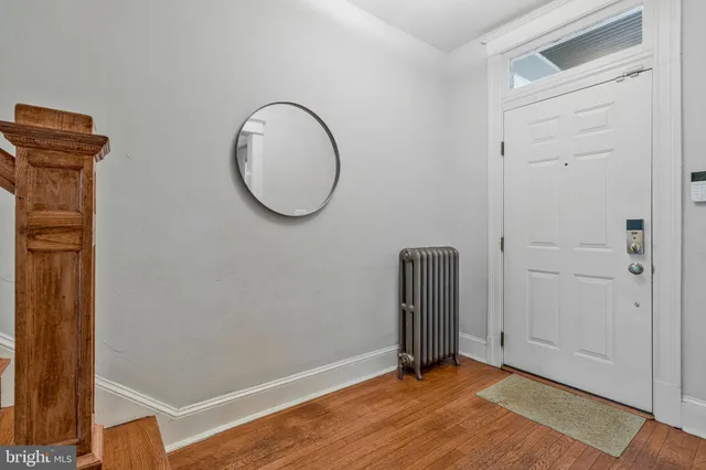a view of a room with wooden floor and a white door