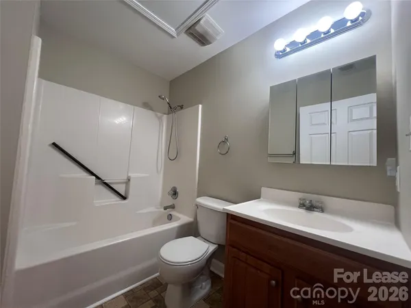 a bathroom with a sink a toilet a mirror and bathtub
