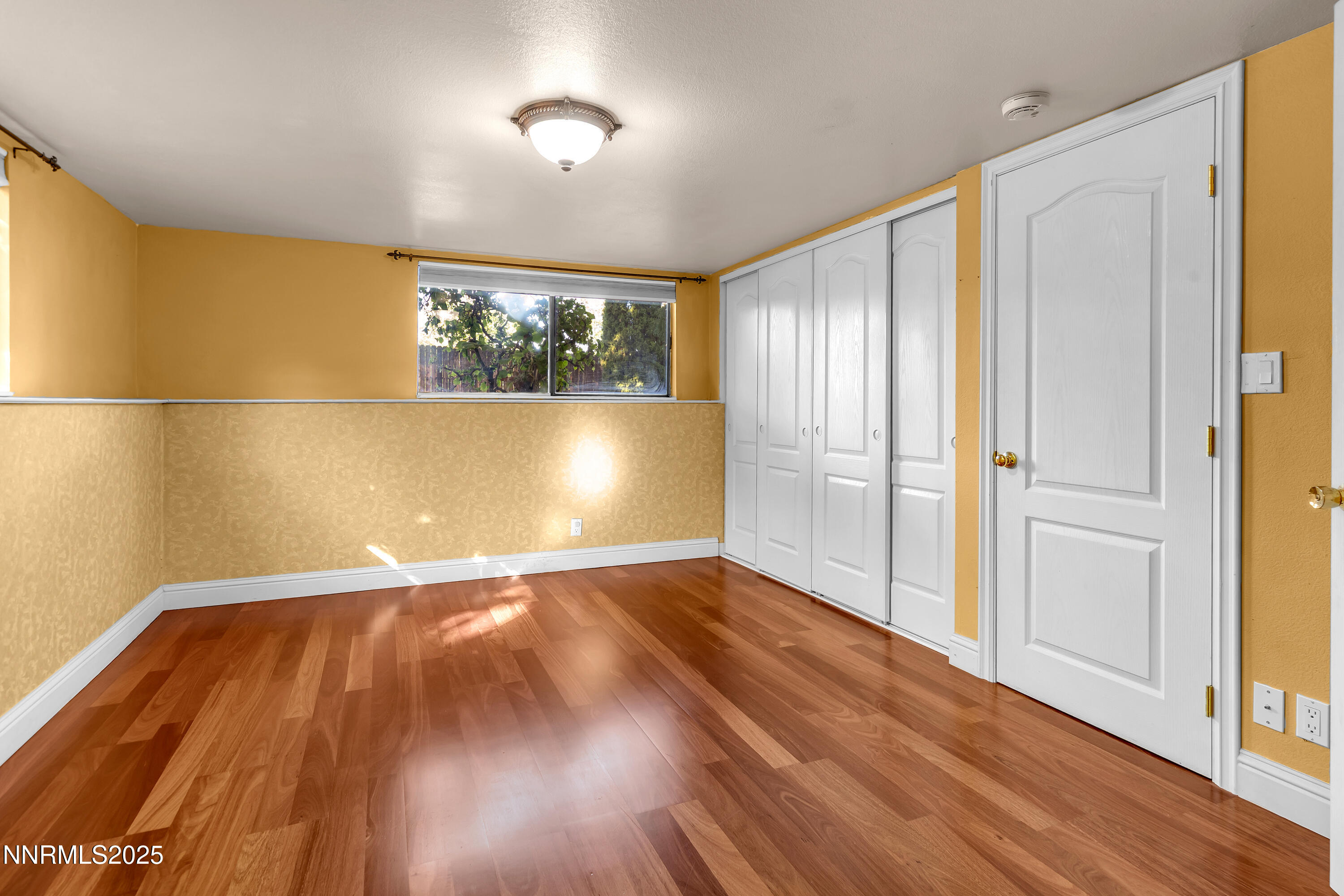 2835 Parkway Drive Reno, NV 89502 - Photo 19 of 39 an empty room with wooden floor and windows