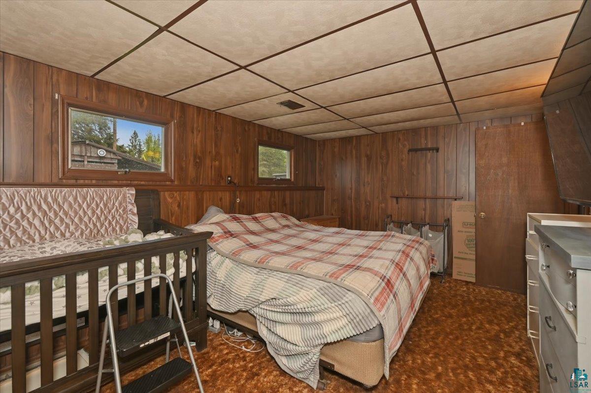 5190 County Road M Gordon, WI 54838 - Photo 17 of 31 Room featuring wood paneling, drop ceiling, and two windows