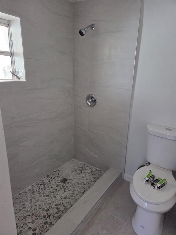 31 Edmund Road, Unit 1 West Park, FL 33023 - Photo 6 of 9 a bathroom with a sink a toilet and shower