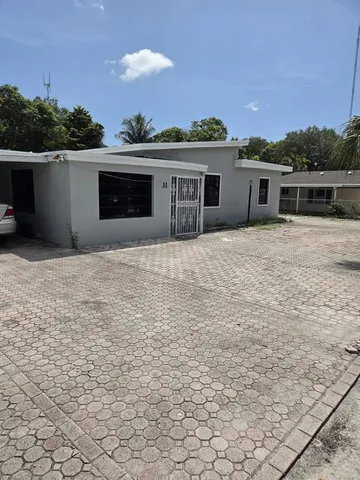 a front view of house with yard and trees in the background