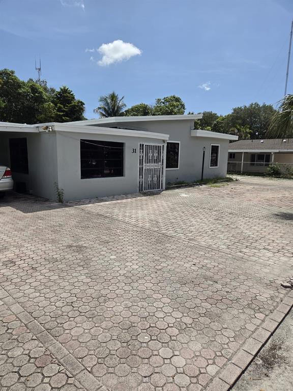 31 Edmund Road, Unit 1 West Park, FL 33023 - Photo 9 of 9 a front view of house with yard and trees in the background