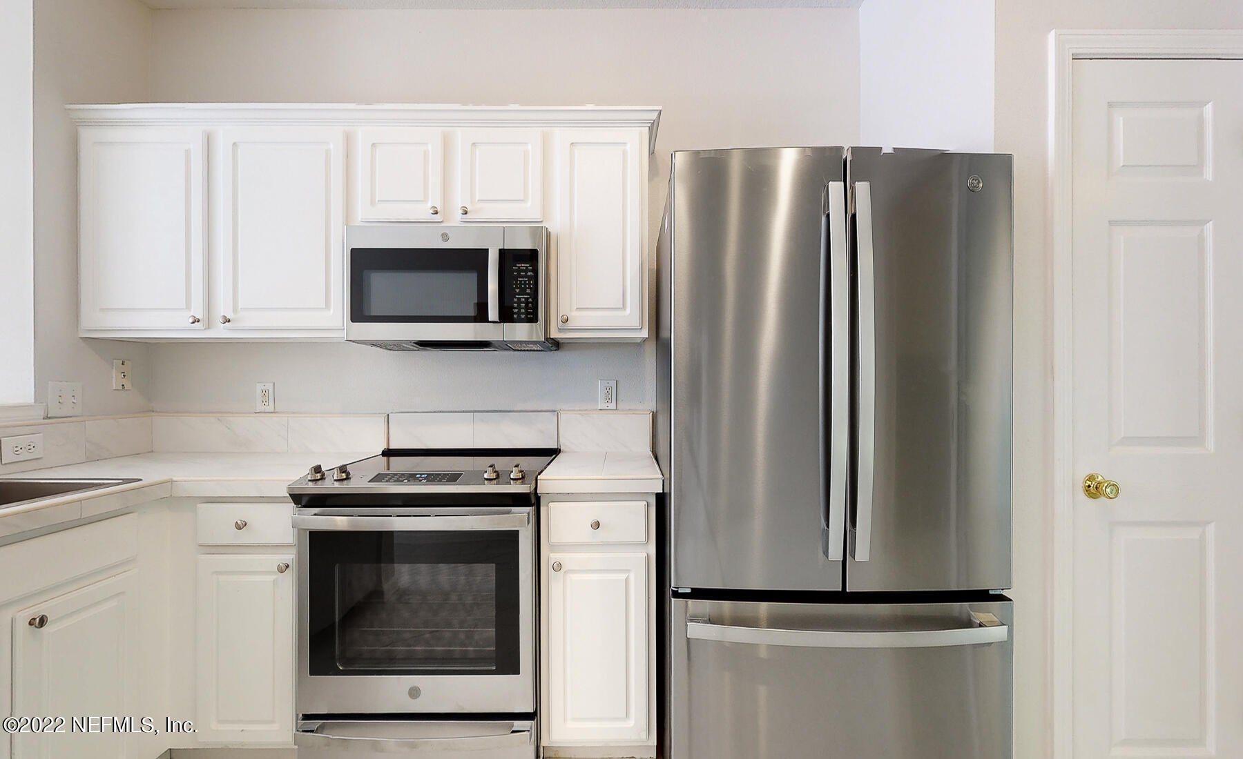 3526 Twisted Tree Lane Jacksonville, FL 32216 - Photo 12 of 33 a kitchen with stainless steel appliances white cabinets and a stove
