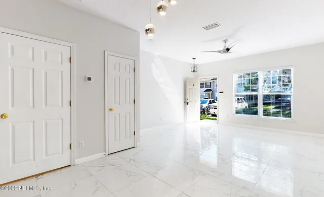 an empty room with windows and cabinet