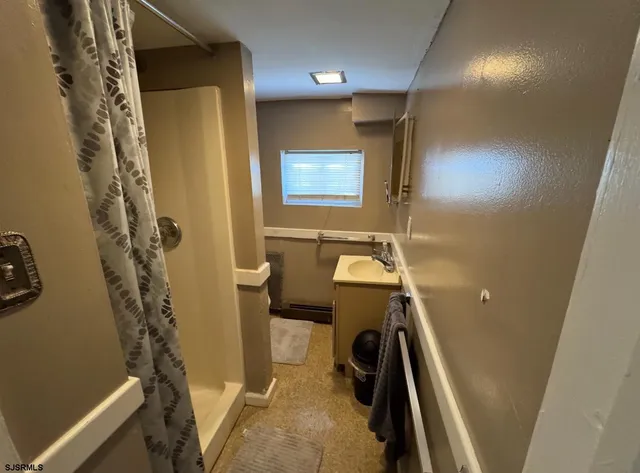 a bathroom with a sink a toilet a mirror and shower
