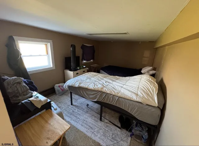 a bedroom with a bed couch and a window