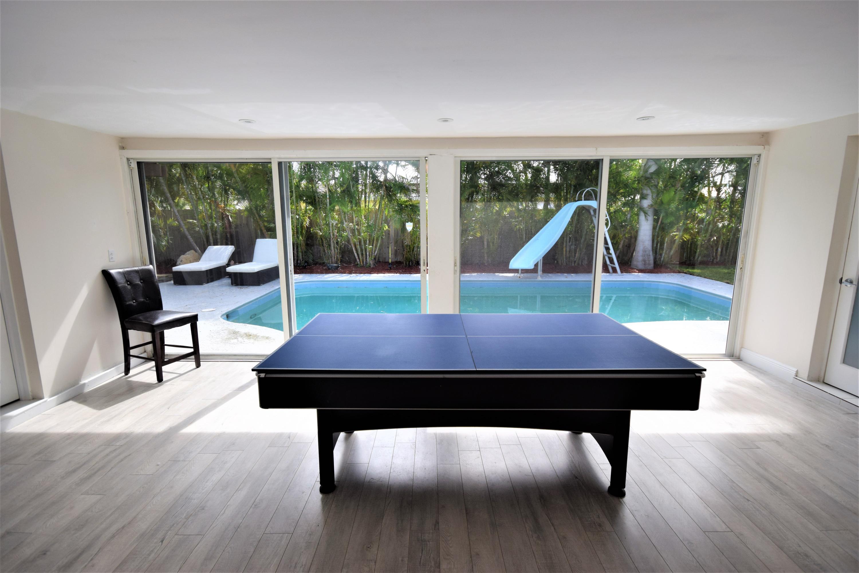 2770 Northeast 25th Terrace Boca Raton, FL 33431 - Photo 22 of 34 a room with wooden floor pool table and windows