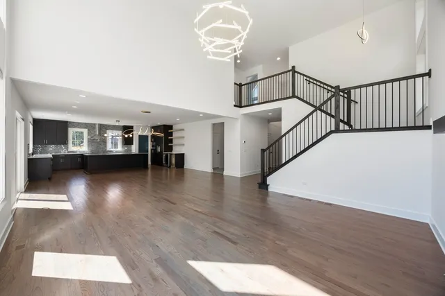 a view of a livingroom with wooden floor and a hallway