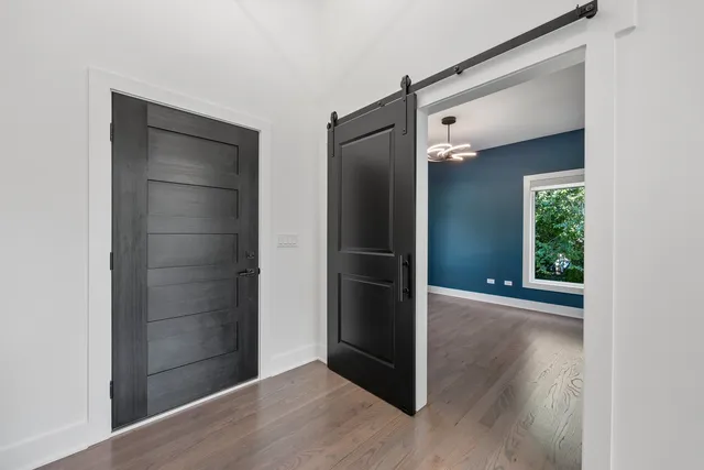 an empty room with wooden floor mirror and windows