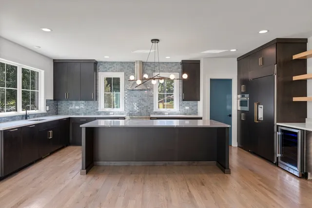 a large kitchen with granite countertop a large counter top stainless steel appliances and cabinets