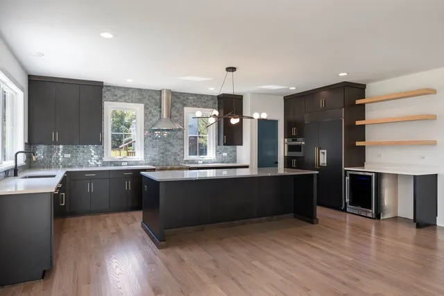 a large kitchen with granite countertop a stove and cabinets