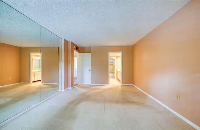 a view of a big room with windows and chandelier fan