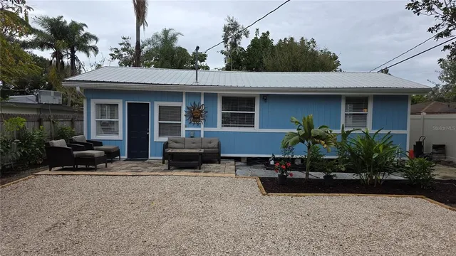 a view of house with outdoor seating and covered in the background