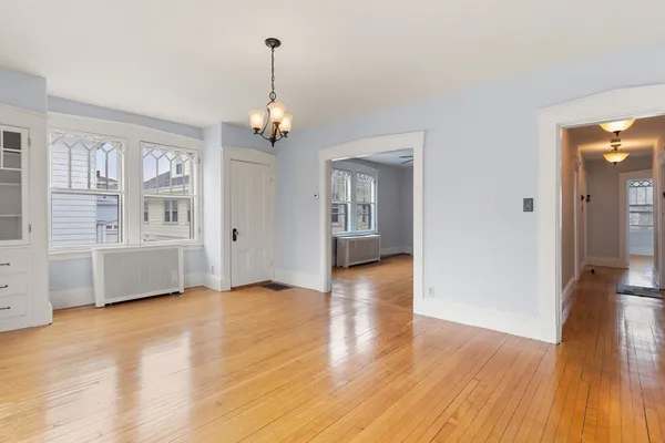 a view of livingroom with chandelier wooden floor and windows