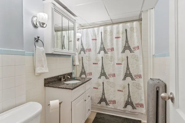 a bathroom with a granite countertop sink a toilet and shower