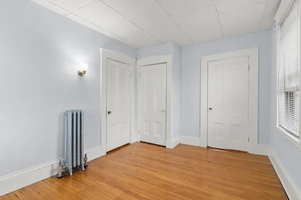 an empty room with wooden floor and closet