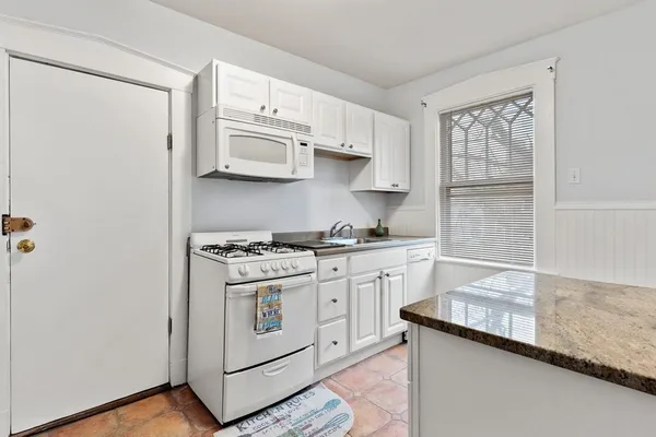 a kitchen with stainless steel appliances granite countertop white cabinets and a stove