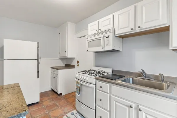 a kitchen with stainless steel appliances granite countertop a sink stove top oven and cabinets