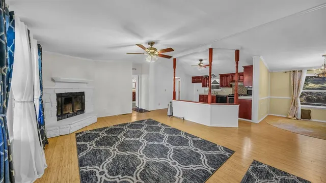 a kitchen with stainless steel appliances granite countertop wooden cabinets a stove a sink and a wooden floor