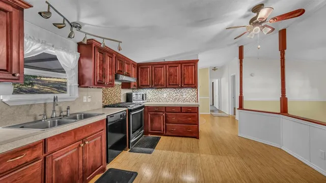 a kitchen with stainless steel appliances granite countertop a sink stove and cabinets