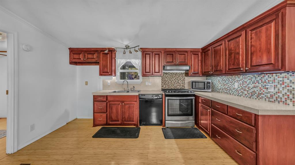 1240 Riverview Road Millsap, TX 76066 - Photo 22 of 36 a kitchen with stainless steel appliances granite countertop a sink stove and cabinets
