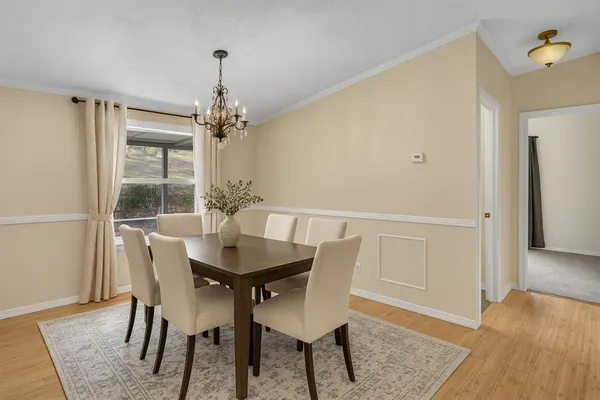 a bedroom with a bed a chandelier and a dresser