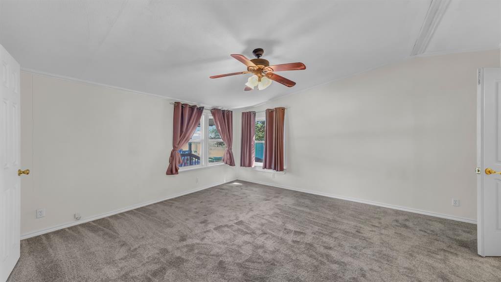 1240 Riverview Road Millsap, TX 76066 - Photo 27 of 36 an empty room with chandelier fan and windows