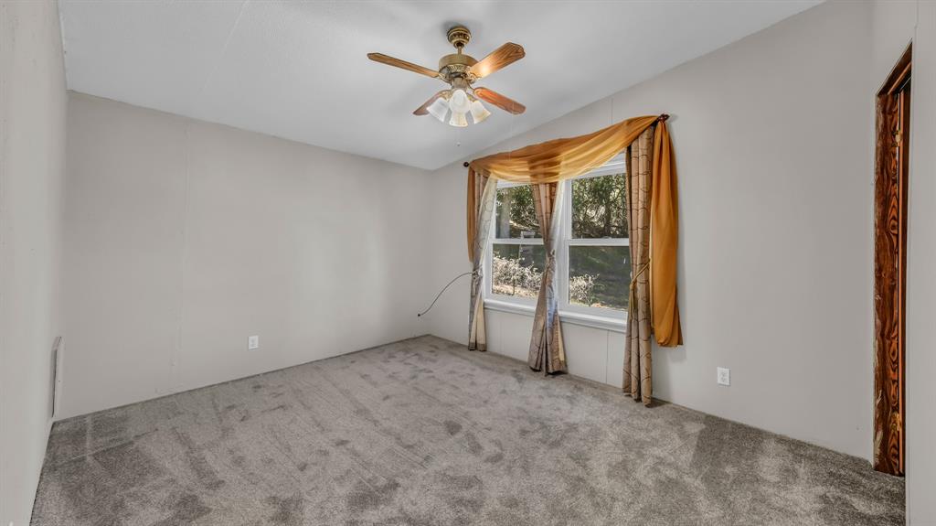 1240 Riverview Road Millsap, TX 76066 - Photo 32 of 36 an empty room with closet and a ceiling fan