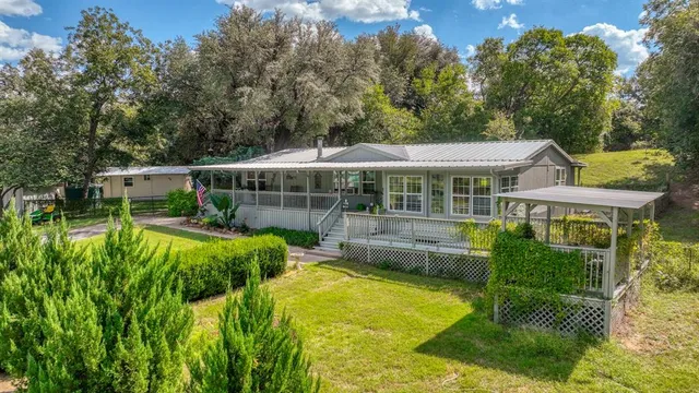 a view of a house with a yard patio and swimming pool
