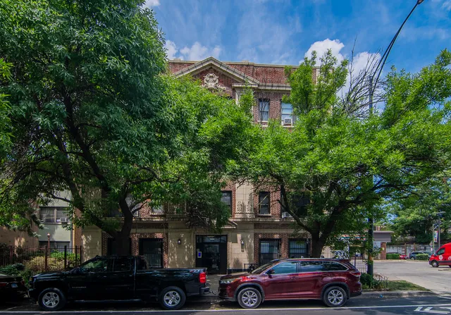 a front view of a building with trees
