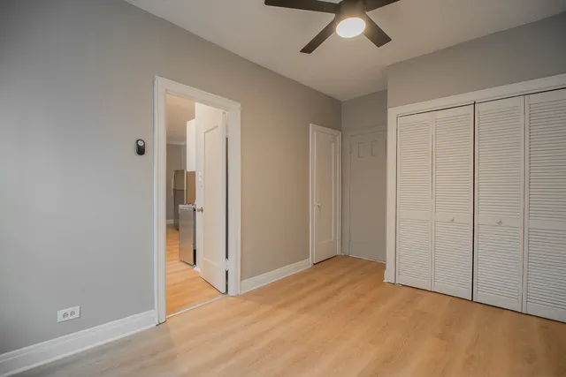 an empty room with fan and entrance