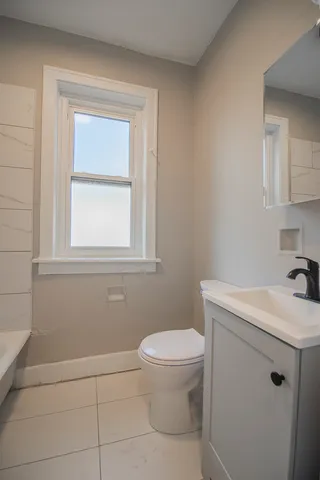 a bathroom with a sink a toilet and a window