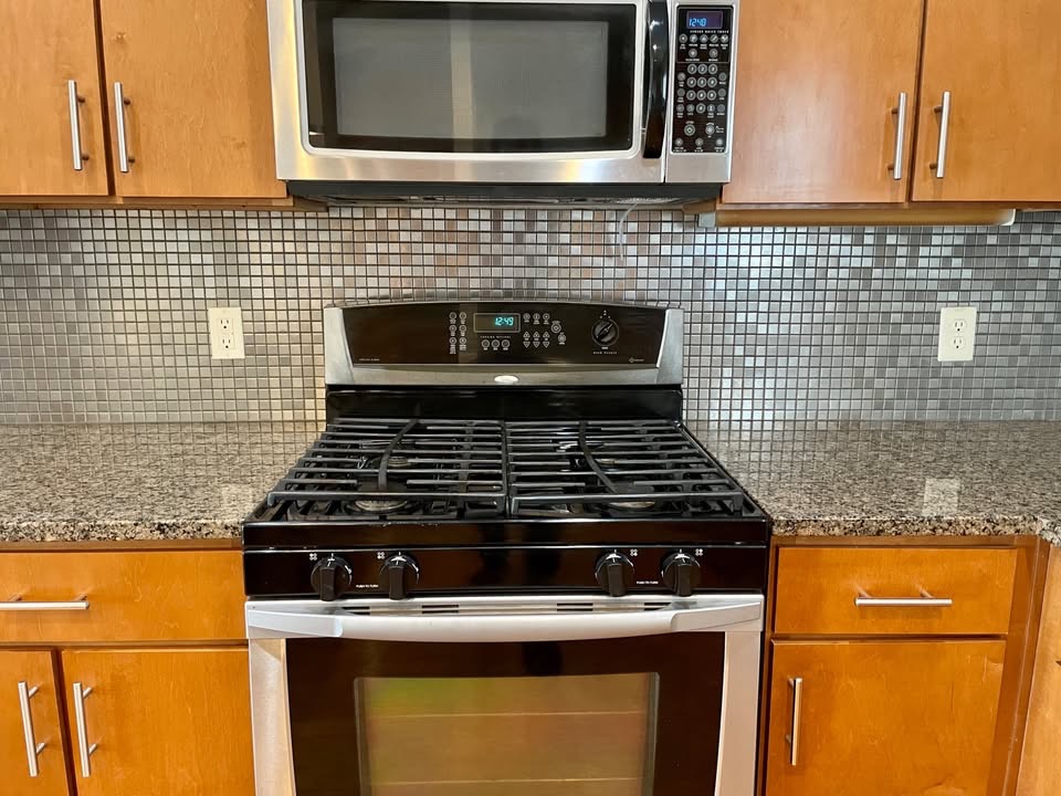 1702 South Lamar Boulevard, Unit 2 Austin, TX 78704 - Photo 7 of 25 Kitchen featuring stainless steel appliances, light stone countertops, tasteful backsplash, and brown cabinetry