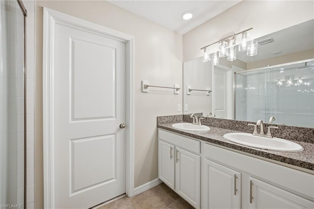 9612 Lemon Drop Loop Sun City Center, FL 33573 - Photo 12 of 33 a bathroom with a granite countertop sink a mirror and a