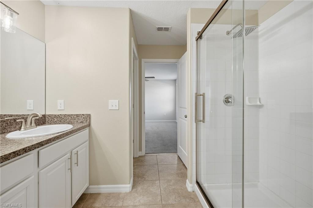 9612 Lemon Drop Loop Sun City Center, FL 33573 - Photo 22 of 33 a bathroom with a granite countertop sink shower and a mirror