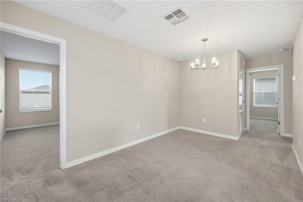 9612 Lemon Drop Loop Sun City Center, FL 33573 - Photo 23 of 33 an empty room with chandelier fan and windows