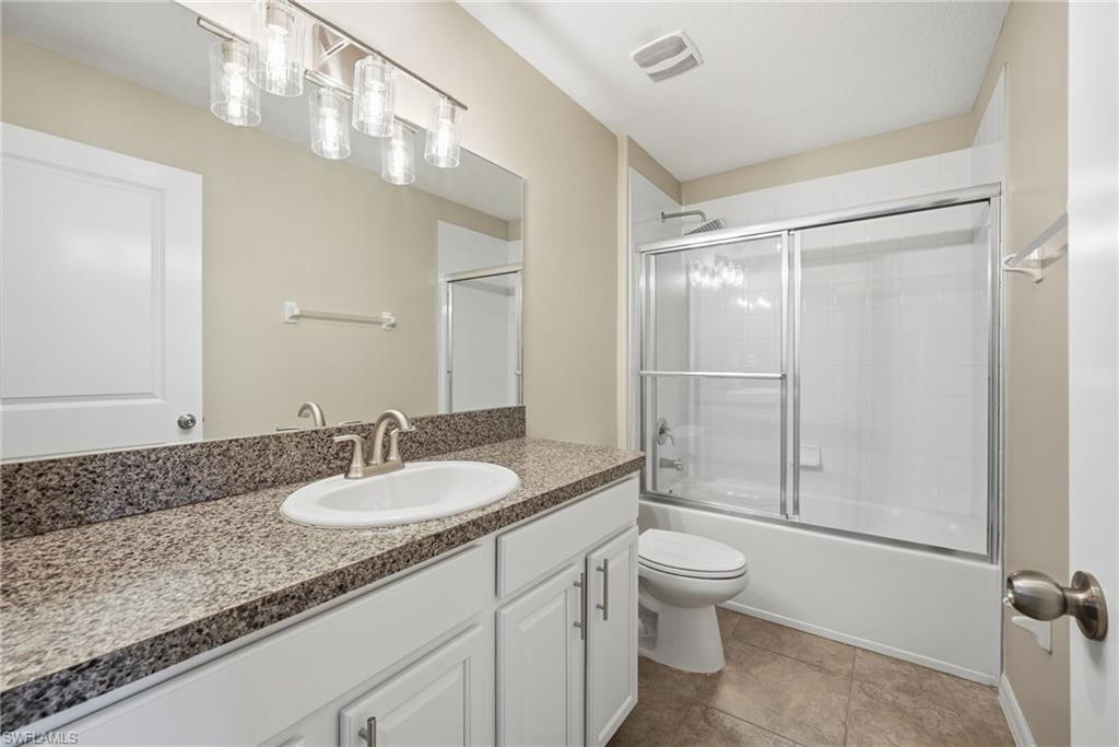 9612 Lemon Drop Loop Sun City Center, FL 33573 - Photo 28 of 33 a bathroom with a granite countertop sink toilet a mirror and shower