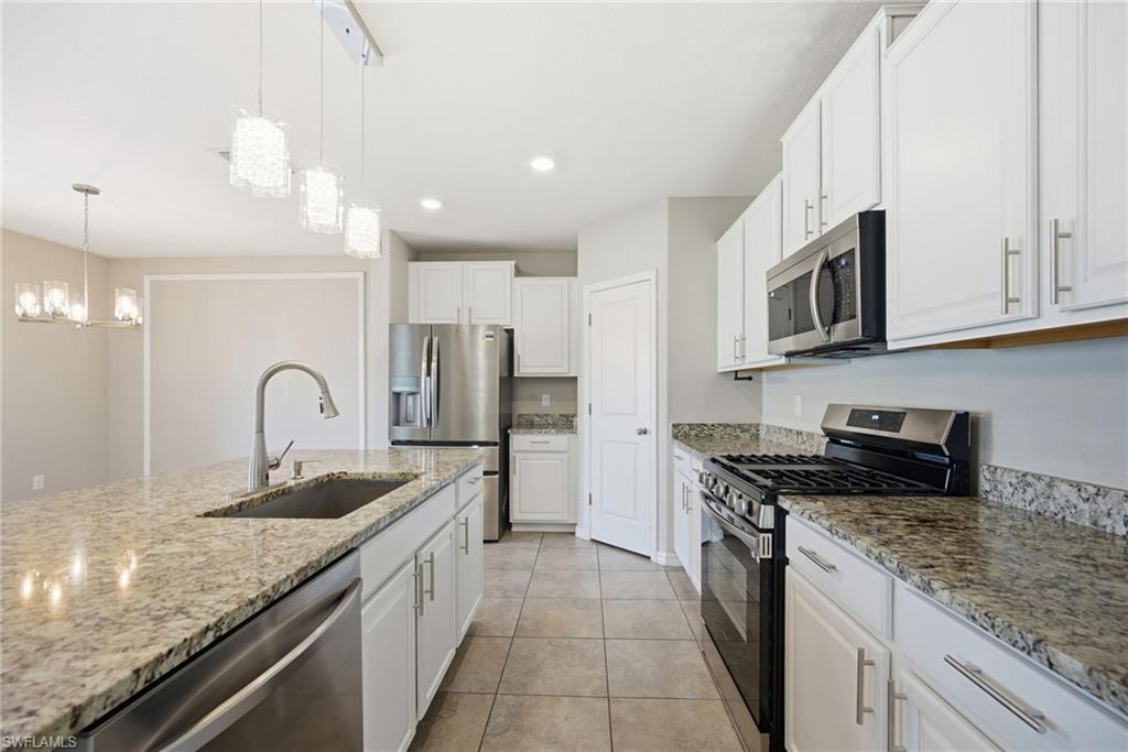 9612 Lemon Drop Loop Sun City Center, FL 33573 - Photo 4 of 33 a kitchen with kitchen island granite countertop stainless steel appliances and a counter space