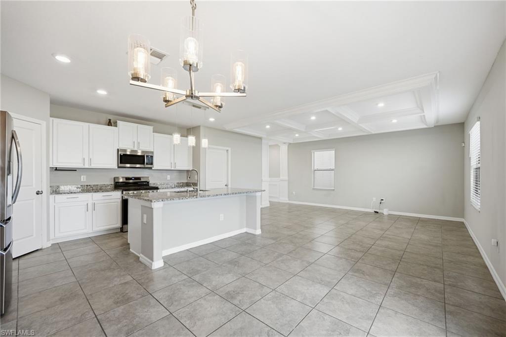 9612 Lemon Drop Loop Sun City Center, FL 33573 - Photo 32 of 33 a open kitchen with kitchen island granite countertop a sink cabinets and stainless steel appliances