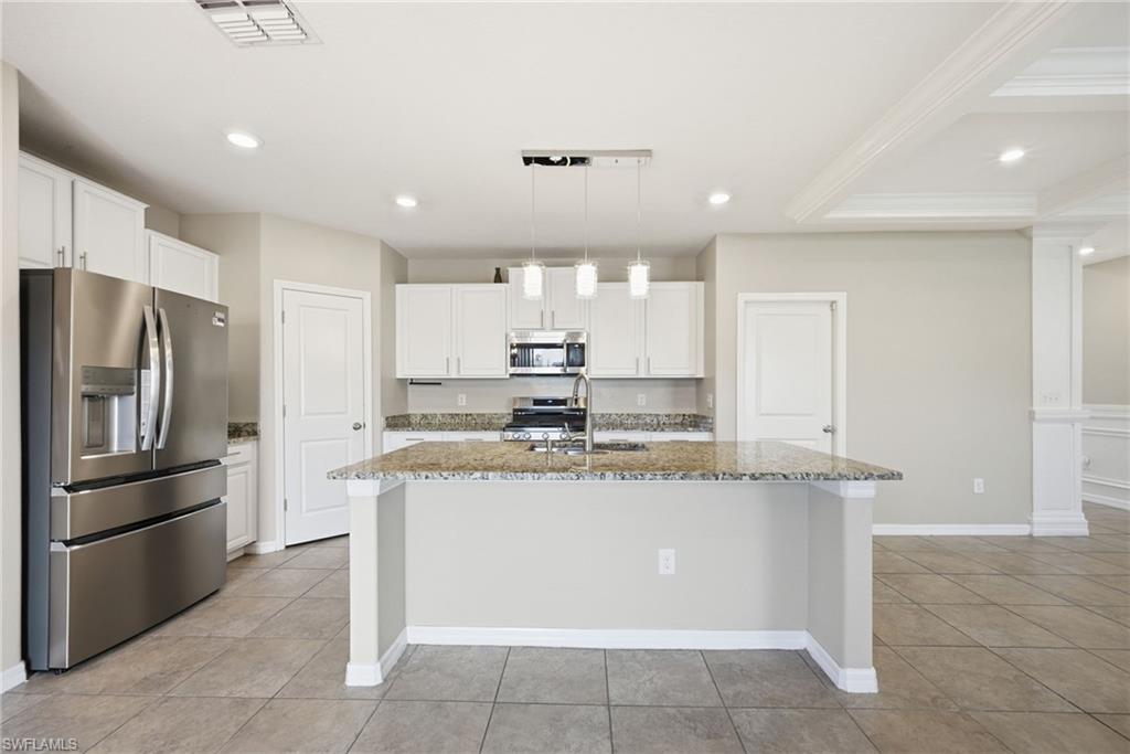 9612 Lemon Drop Loop Sun City Center, FL 33573 - Photo 8 of 33 a view of a kitchen with kitchen island a sink stainless steel appliances and cabinets