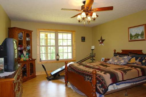 569 Sam Reed Road Northwest Floyd, VA 24091 - Photo 10 of 22 a bedroom with a bed and a chandelier