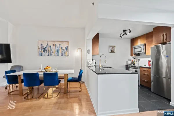 a living room with stainless steel appliances kitchen island granite countertop furniture a refrigerator and a sink