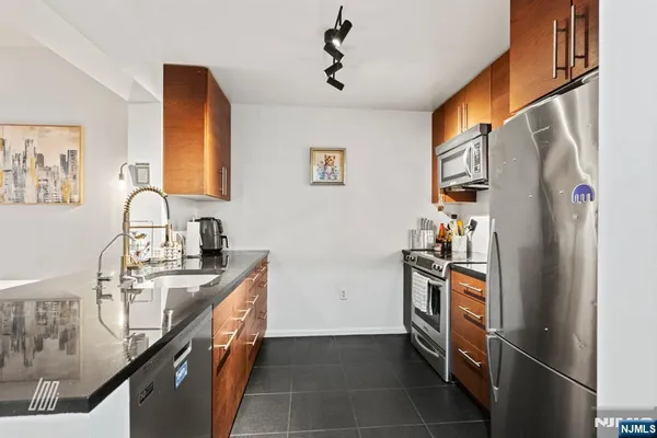 a kitchen with stainless steel appliances granite countertop a refrigerator and a stove top oven