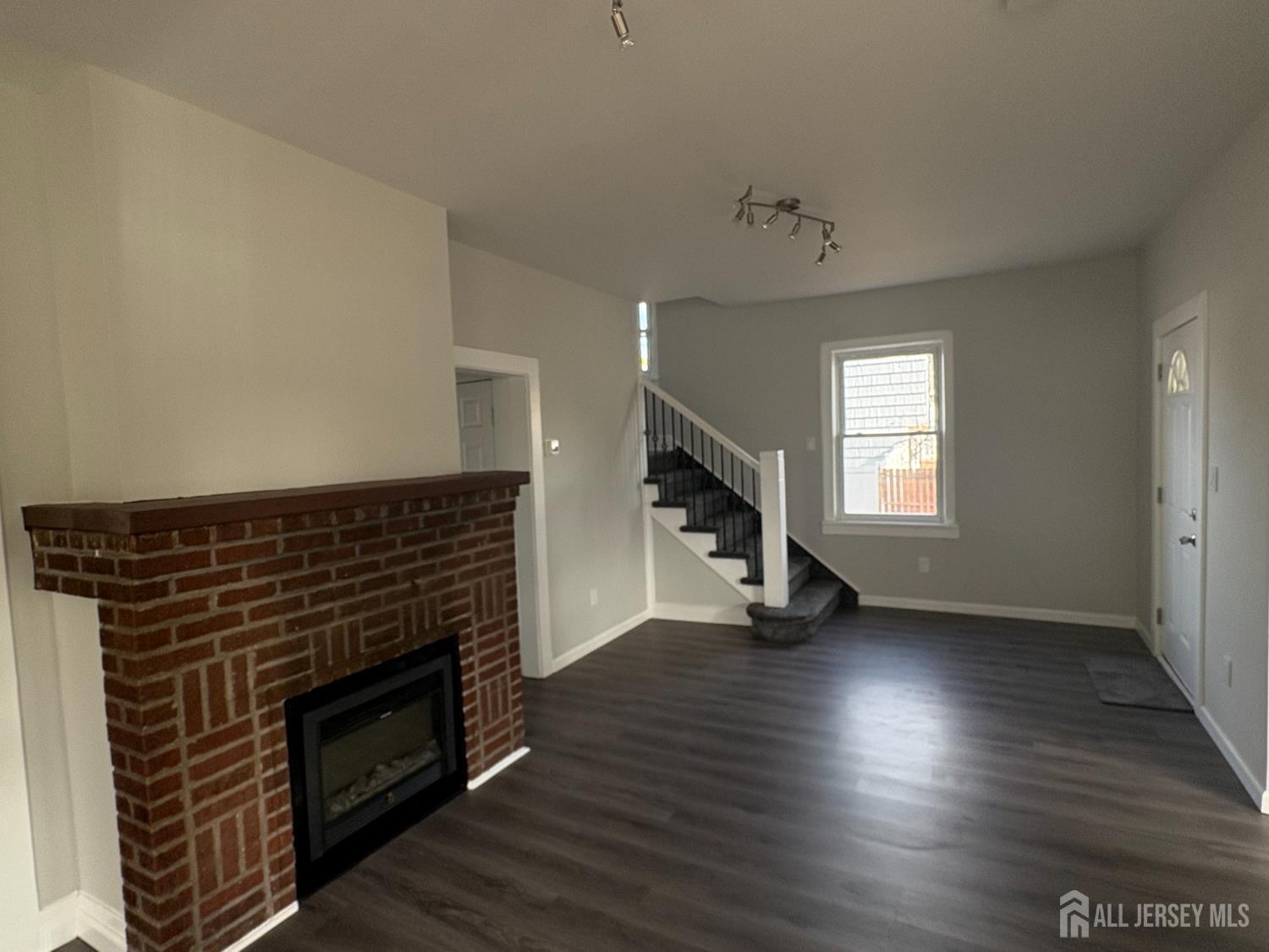 111 Doyle Street Piscataway, NJ 08854 - Photo 11 of 18 a view of an empty room with wooden floor fireplace and a window
