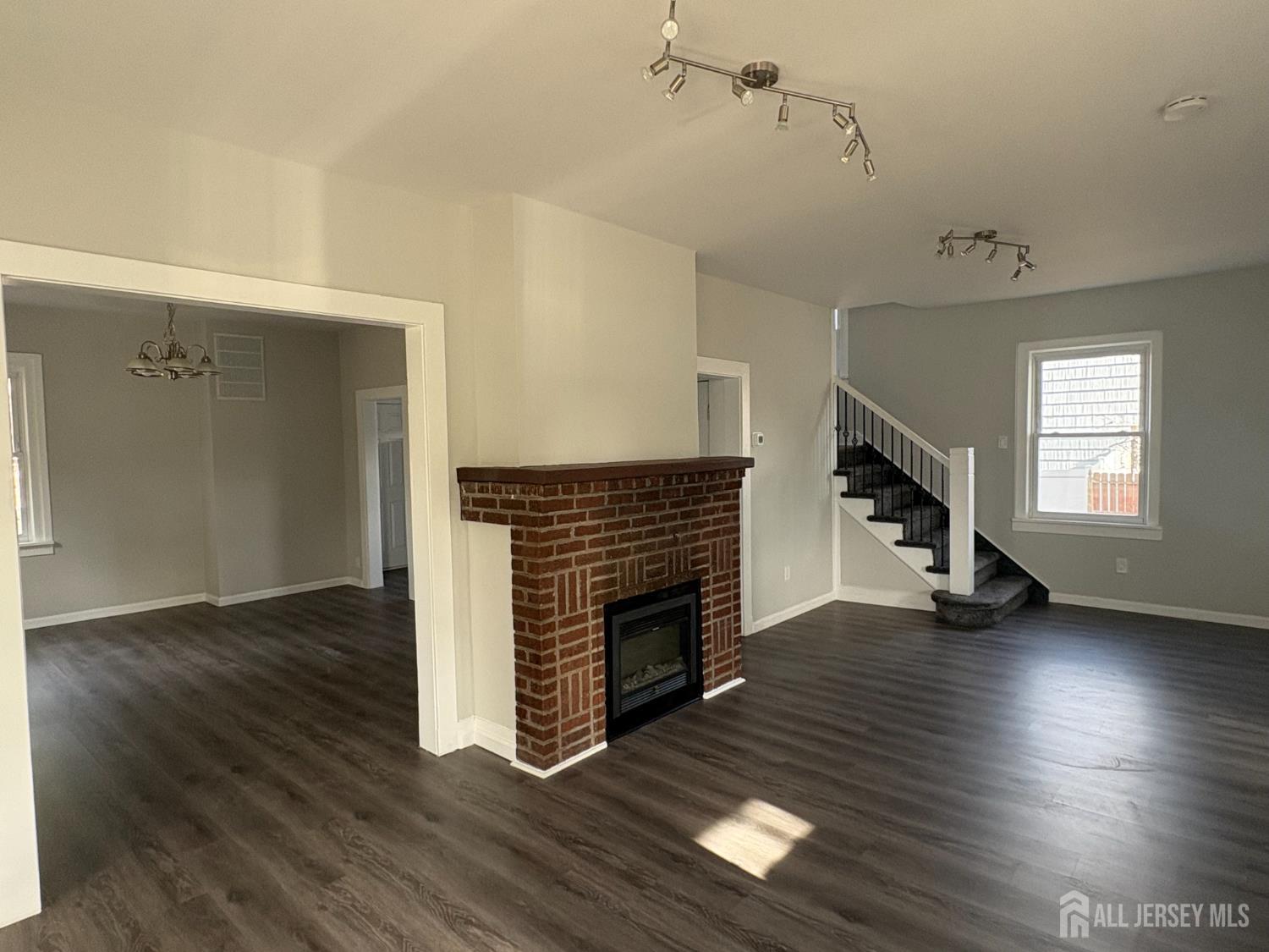 111 Doyle Street Piscataway, NJ 08854 - Photo 12 of 18 an empty room with wooden floor fireplace and windows