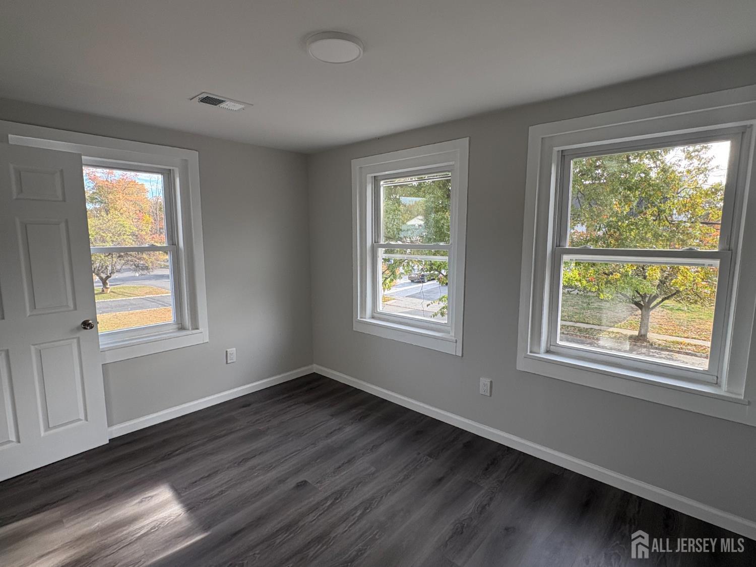111 Doyle Street Piscataway, NJ 08854 - Photo 13 of 18 a view of an empty room with wooden floor and a window