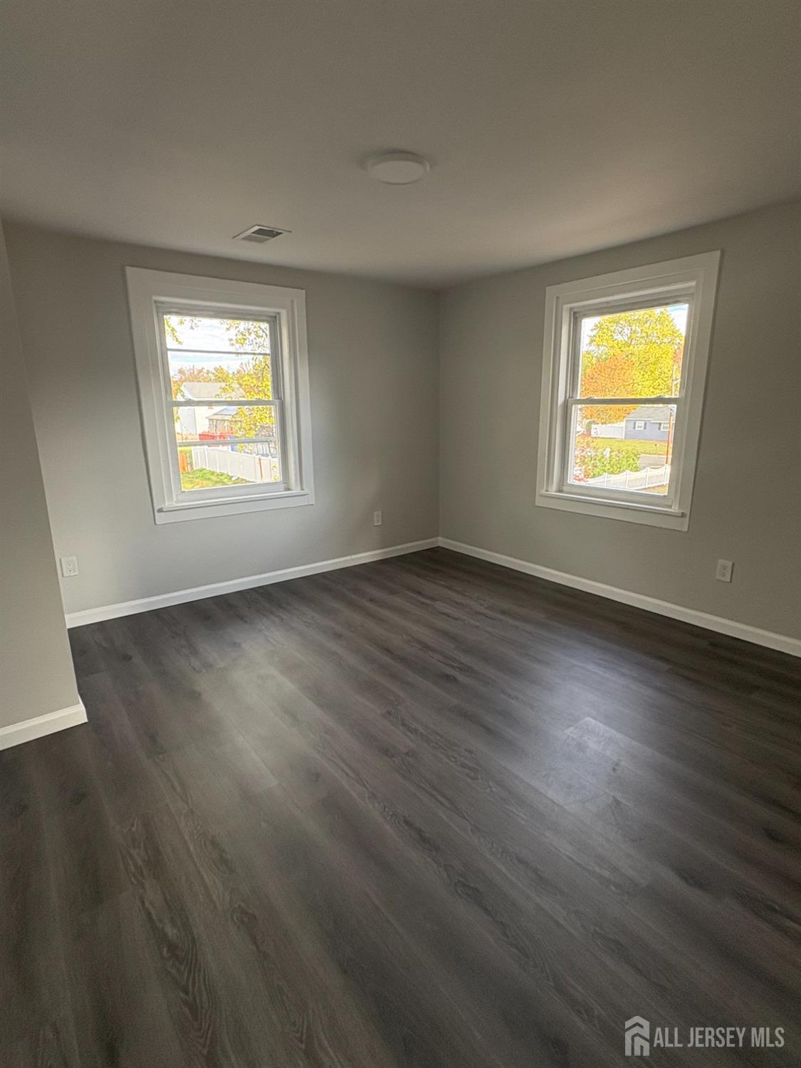111 Doyle Street Piscataway, NJ 08854 - Photo 14 of 18 an empty room with wooden floor and windows