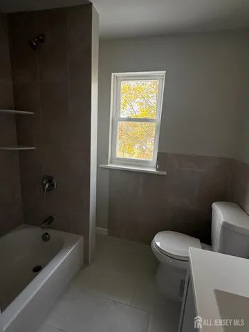 a white toilet sitting next to a bathtub
